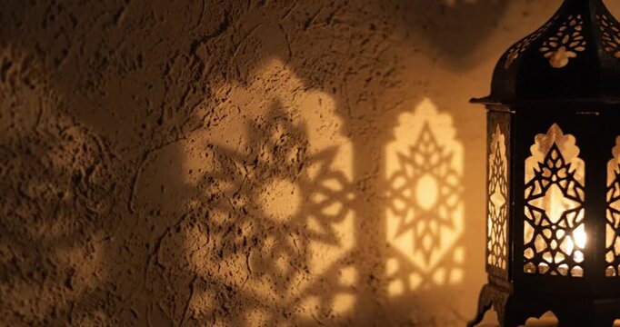 Decorative metal lantern casting intricate geometric light patterns on a textured wall, warm ambient mood lighting.