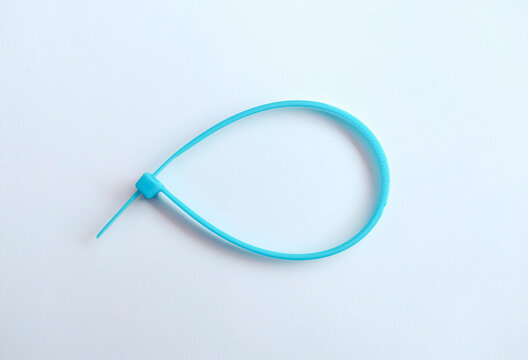 Blue plastic cable tie or zip tie isolated on a white background