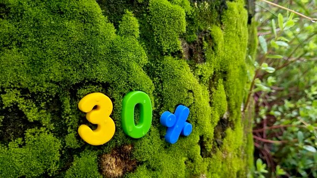 Thirty percent symbol attached to mossy tree trunk moss nature numbers discount offer