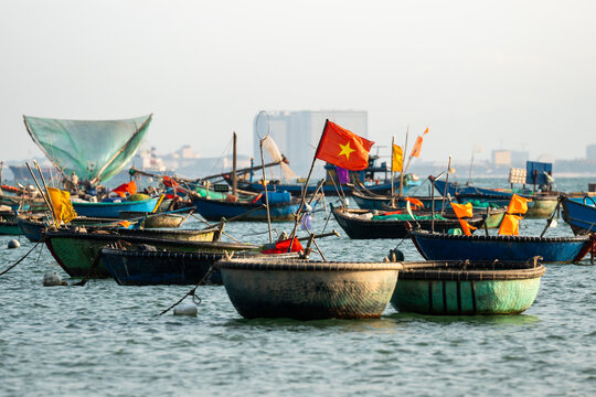 Several traditional Vietnamese bamboo basket and fish boats for seafood fishing with gear and nets, authentic fishing fleet of local fishermen in Vietnam, bay area filled with boats and vessels.