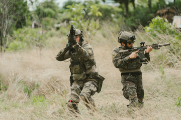Fototapeta premium Outdoor military concept. Soldier tactical training maneuver with focus and determination, military personnel on field duty in camouflage gear with weapon and uniform