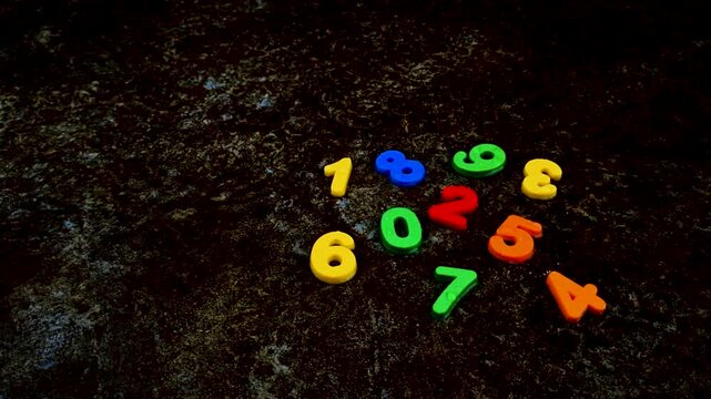 Group of colorful plastic numbers on dark textured surface number math mathematics counting