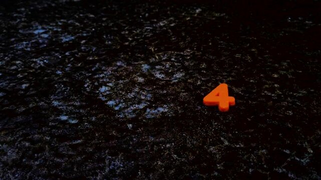 Orange number four on dark textured surface digit weathered texture ground concrete