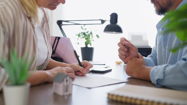 Female client finalize home purchase by sign contract and receiving keys from a real estate agent in a professional office. Successful property closing, new home and completed real estate deal concept