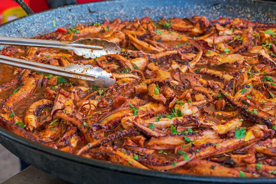 Background with fillets of octopus in a big pan and ready for cooking. Specific for mediterranean food.