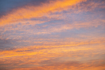 Obraz premium Dramatic sunset sky with orange and purple clouds. Golden hour light illuminating heaven.
