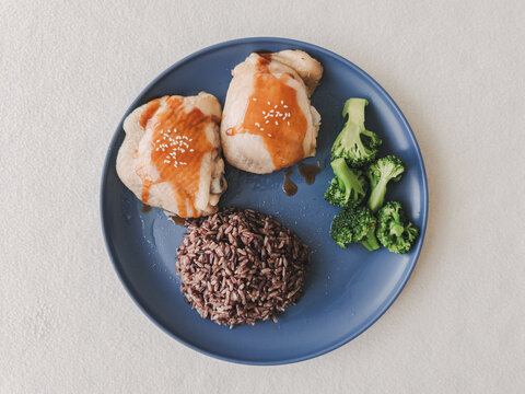 Healthy Chicken and Black Rice Meal with Steamed Broccoli on a Blue Plate