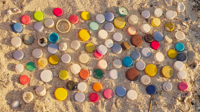 plastic bottle cap on sandy beach pollution, stop motion., single-use microplastics concepts