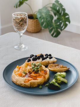 Healthy breakfast plate with savory vegetable omelet, sweet blueberry toast, and crunchy broccoli.