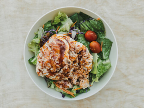 Healthy and fresh salad bowl with shredded chicken, crisp greens, and cherry tomatoes.