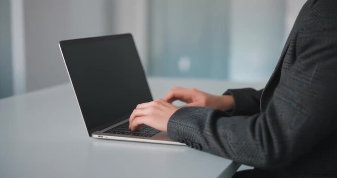 Person typing on a laptop computer in an office setting