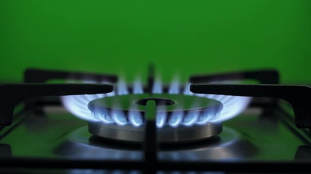 Gas stove burner with blue flame igniting and burning in sequence against a green background