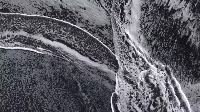 Aerial Top Down View of White Foam Ocean Waves Crashing on Black Sand Beach