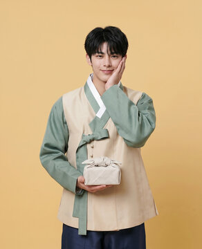 선물을 들고 볼에 손을 댄 한복 남성 / Hanbok Man Holding a Gift with Hand on Cheek