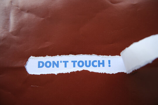 The words "DON'T TOUCH" are written on the back of the torn piece of paper. A warning not to touch.