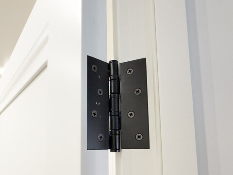 An Up-Close View of a Modern Black Door Hinge Showcasing Its Unique Design and Functionality for Interior and Exterior Doors