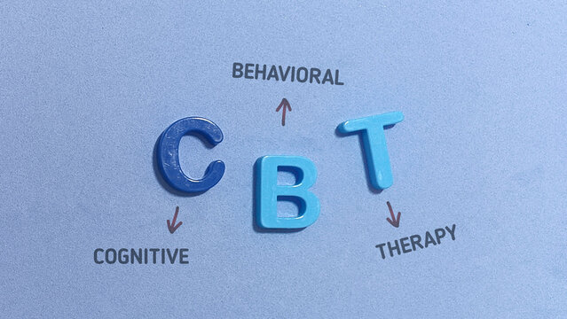 Conceptual flat lay image featuring colorful plastic letter blocks spelling CBT with handwritten annotations explaining Cognitive Behavioral Therapy.