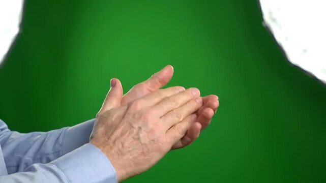 Close-up shot of hands clapping against green backdrop