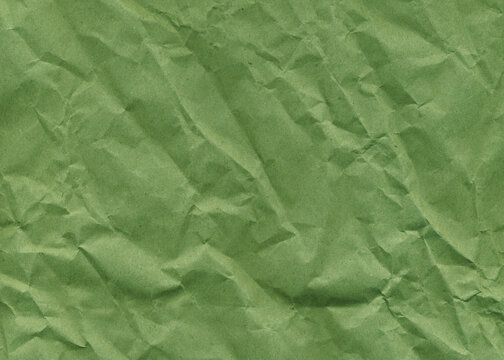 Packing crumpled green paper texture. Craft paper texture for design. Vintage paper antique texture.