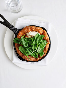 Dutch baby pancake with fresh spinach and cheese, brunch menu concept for cafes and restaurants