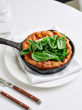Dutch baby pancake with avocado and baby spinach leaves, brunch menu, healthy dining concept