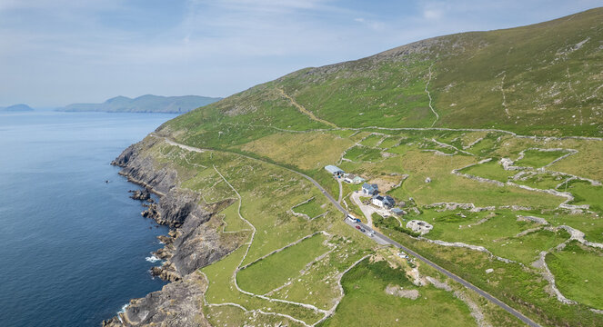 Drone Aerial scenery landscape view dingle peninsula coastline, cliffs, green fields, and a small rural village. Irish farmland Ireland