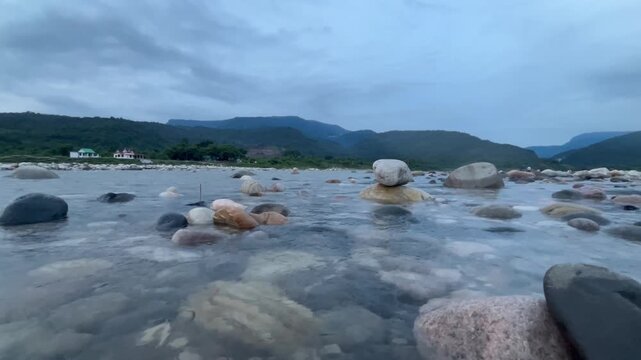 The water flows down the mountain slopes and merges into a rocky lake.