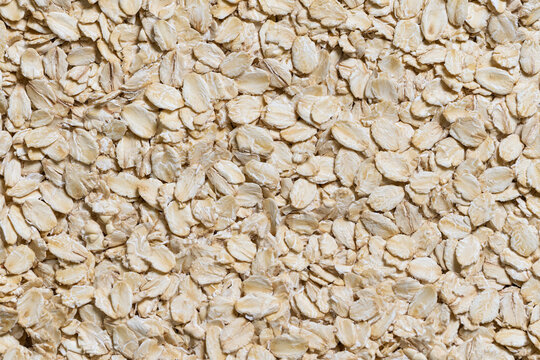 Close-up background texture of dry raw oatmeal flakes full frame