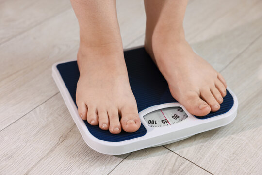 Overweight woman on scale at home, closeup