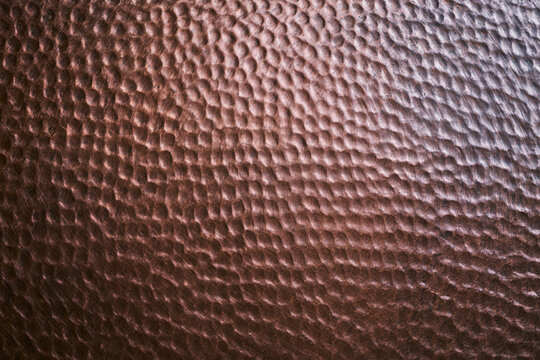 Hammered copper metal surface texture background with dimpled pattern