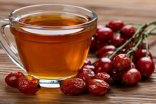 Cup of herbal tea with fresh rose hips