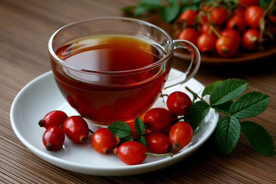 Cup of tea with red berries on a wooden table