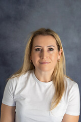 Obraz premium Portrait of young beautiful woman in jeans and T-shirt look at camera pose for picture, pretty millennial blond female model with long hair isolated on grey studio background