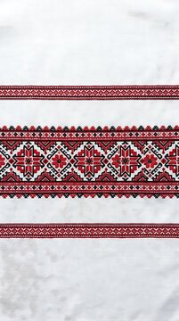Traditional ukrainian embroidery pattern with red and black geometric floral motifs on white fabric