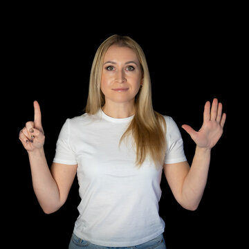 Young blonde woman white t-shirt standing over black background pointing fingers up showing numbers. number six, six fingers