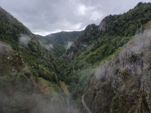 Scenic view of Transfagarasan mountain road winding through foggy valley, Fagaras Mountains, Romania