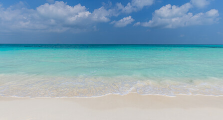 Fototapeta premium Vibrant turquoise sea calm ocean waves blue sunny sky fluffy clouds tropical summer horizon. Peaceful minimal seascape nature landscape. Bright paradise wellbeing backdrop scenic panoramic wallpaper