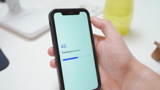 Hand holding smartphone with parcel tracking app showing loading and error message