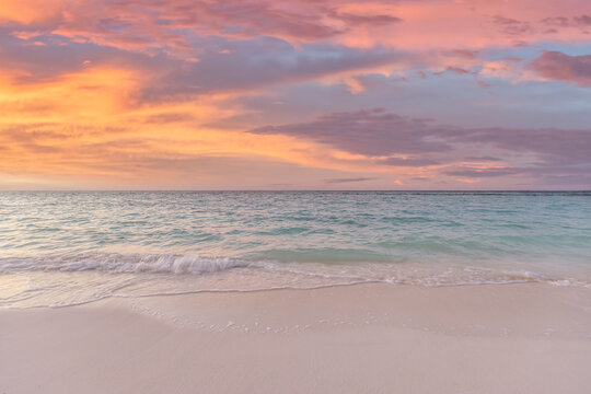 Dreamy closeup pastel sunset calm sea soft sand glowing sky tropical beach shore evening. Peaceful summer seascape nature landscape. Meditation wellbeing backdrop warm romantic coastal background