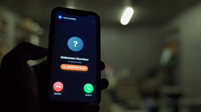 Hand holding smartphone with incoming call from unknown number then call blocked screen