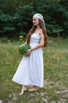 Cottagecore style girl with fresh watermelon walking in nature