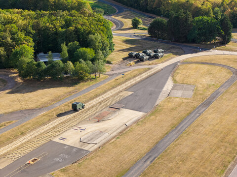 Military Vehicle Undergoes Testing on an Outdoor Track at a Facility in Daylight