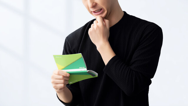 通帳を見て困る男性, Worried Man Looking at a Bankbook