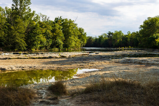 Partially dried-up course of the Ari&egrave;ge river in summer 2026, marked by severe heat waves and significant drought, seen from the Ramier de la Riverotte at Clermont-le-Fort