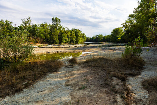 Partially dried-up course of the Ari&egrave;ge river in summer 2026, marked by severe heat waves and significant drought, seen from the Ramier de la Riverotte at Clermont-le-Fort