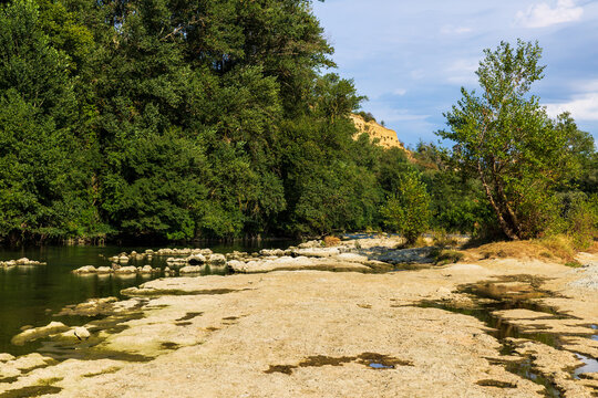 Partially dried-up course of the Ari&egrave;ge river in summer 2026, marked by severe heat waves and significant drought, seen from the Ramier de la Riverotte at Clermont-le-Fort