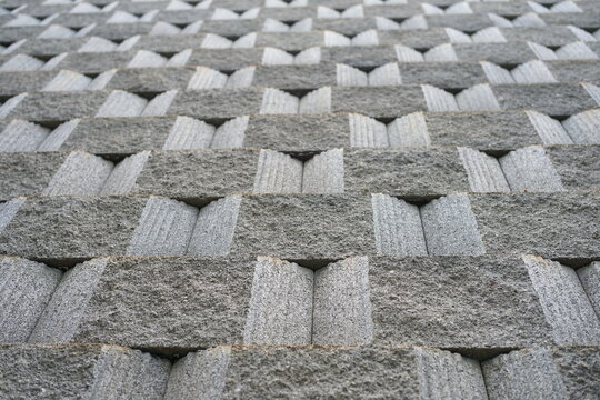 Gyeongju,South Korea - August 8,2026:A sturdy concrete retaining wall with symmetrical geometric patterns,built from sand and small stones to prevent soil erosion in Gyeongju,South Korea on 8-08-2026
