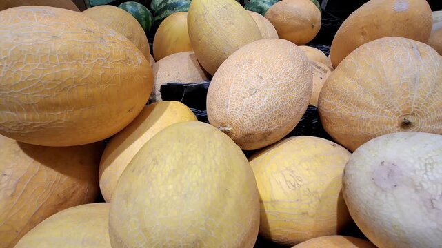 Fresh cantaloupes arranged in a market display. Melons, healthy fruit, natural produce, summer food, grocery shopping.