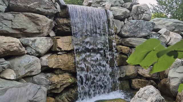 Powerful water flowing over mossy rocks at waterfall