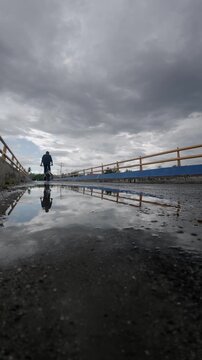 Slow Motion of Cyclist Riding on Bridge with Reflection